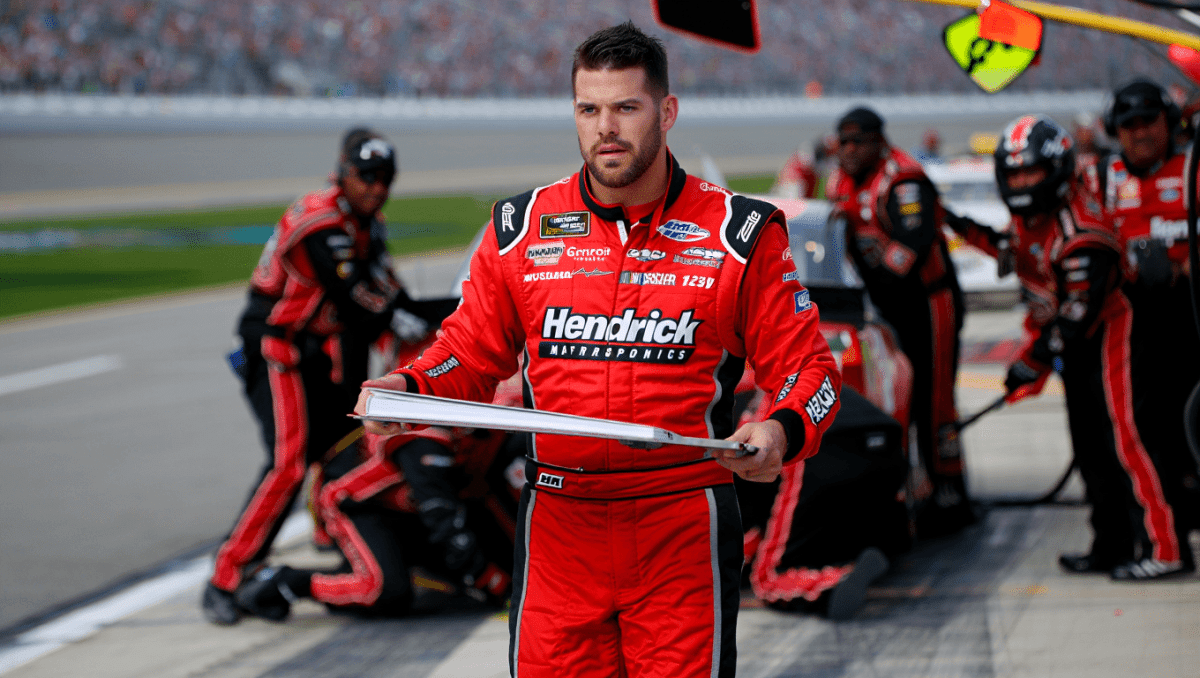 Jason Kelce works NASCAR pit crew at Talladega Superspeedway, holds car sign for No. 17