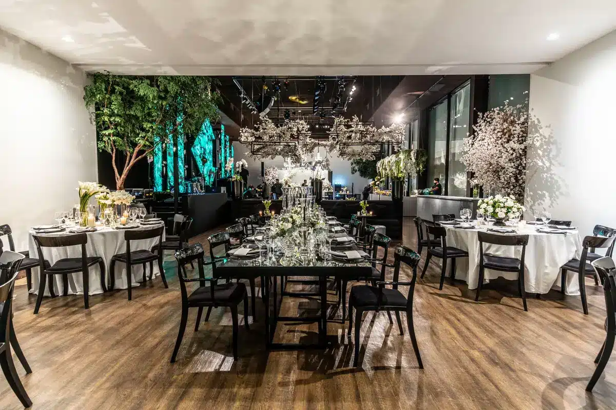 Formal black-tie dinner setting with guests and contemporary artworks displayed for live auction.