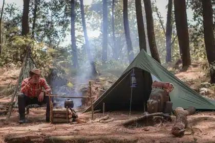 A person navigating a challenging outdoor terrain during a survival test in remote wilderness.