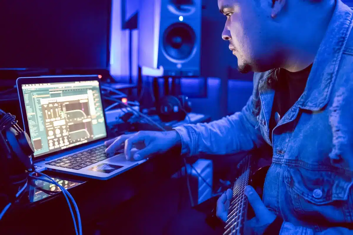 Productor aprendiendo software de producción musical en una laptop