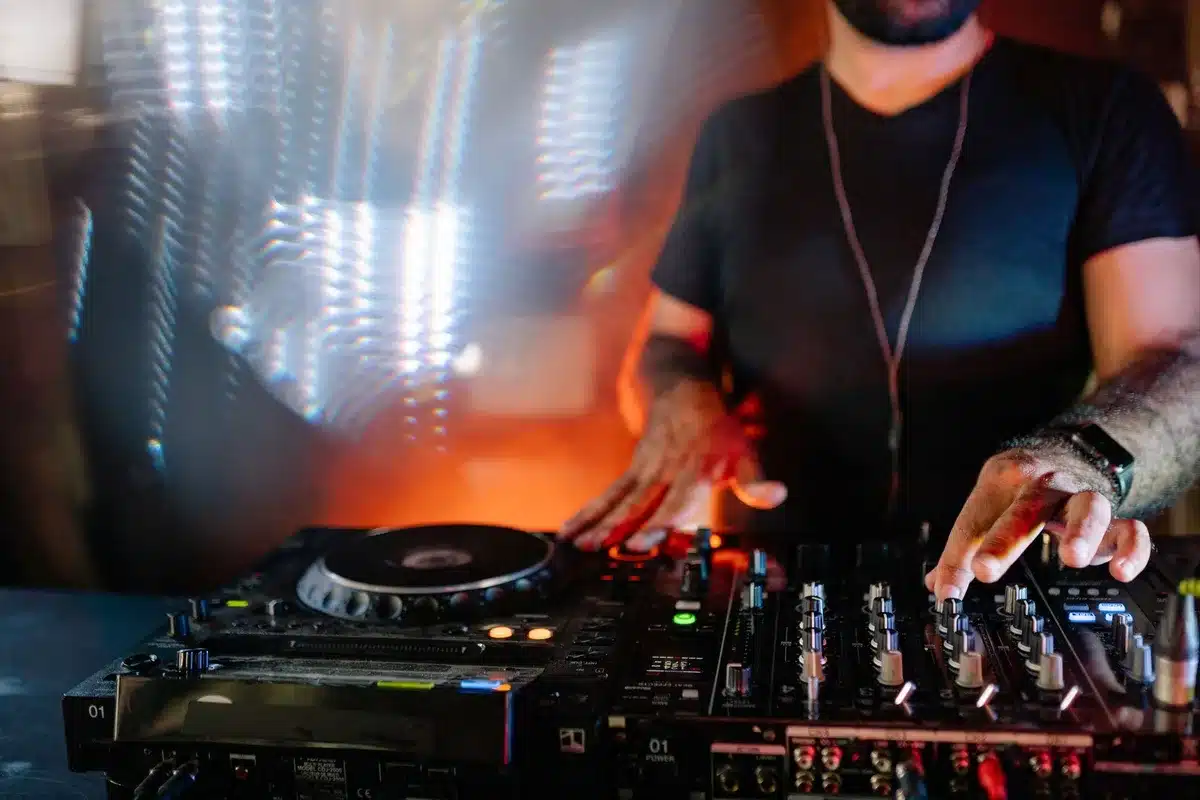 DJ trabajando en equipos de mezcla durante una sesión de club