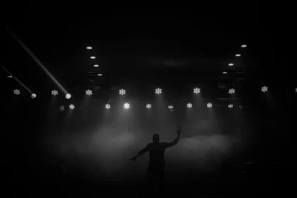 An actress on stage under spotlight in an empty theater