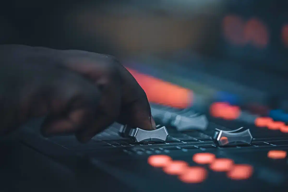 Sound engineer working at a professional mixing console with multiple audio tracks displayed