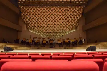 Professional recording studio with multiple actors at microphones, conductor, and sound engineer at mixing console
