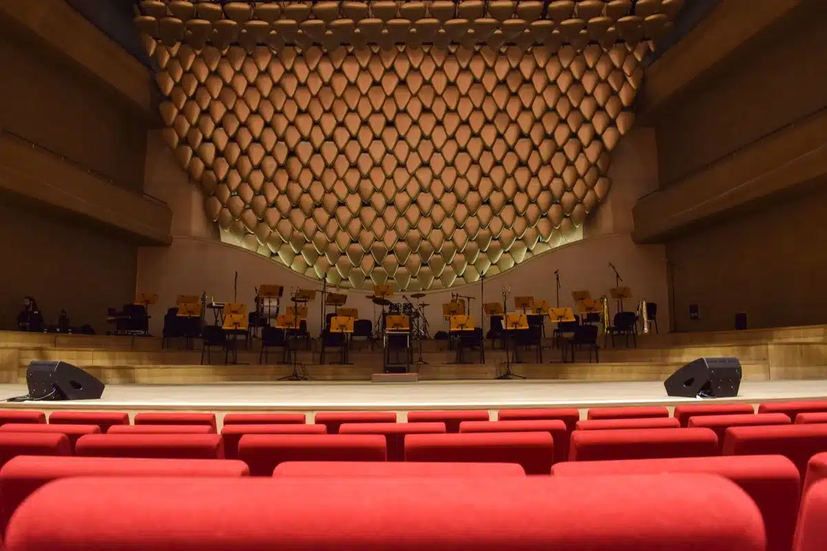 Professional recording studio with multiple actors at microphones, conductor, and sound engineer at mixing console