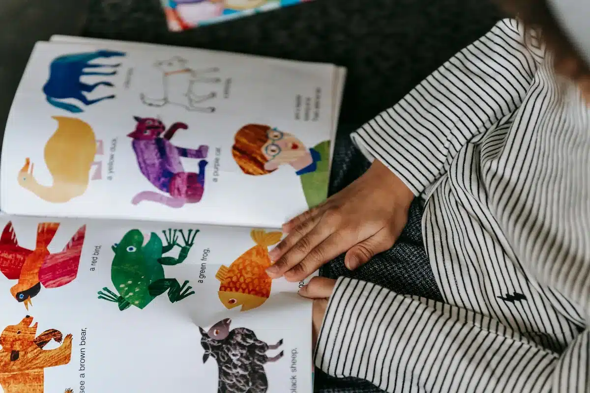 Children sitting together and reading a picture book, discovering stories about confidence and courage.