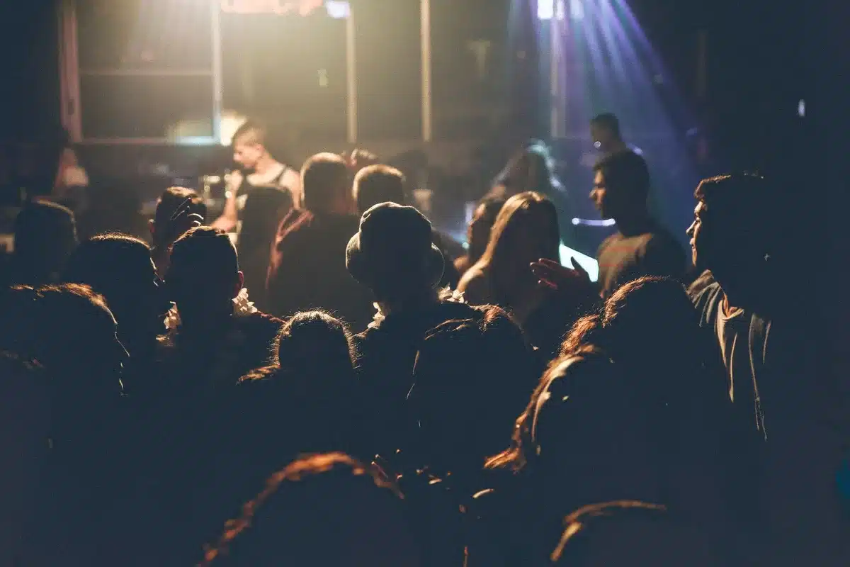 Performers on stage engaging with a packed crowd during a K-pop concert