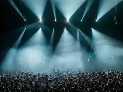 Packed arena crowd with raised phone lights during a K-pop concert performance