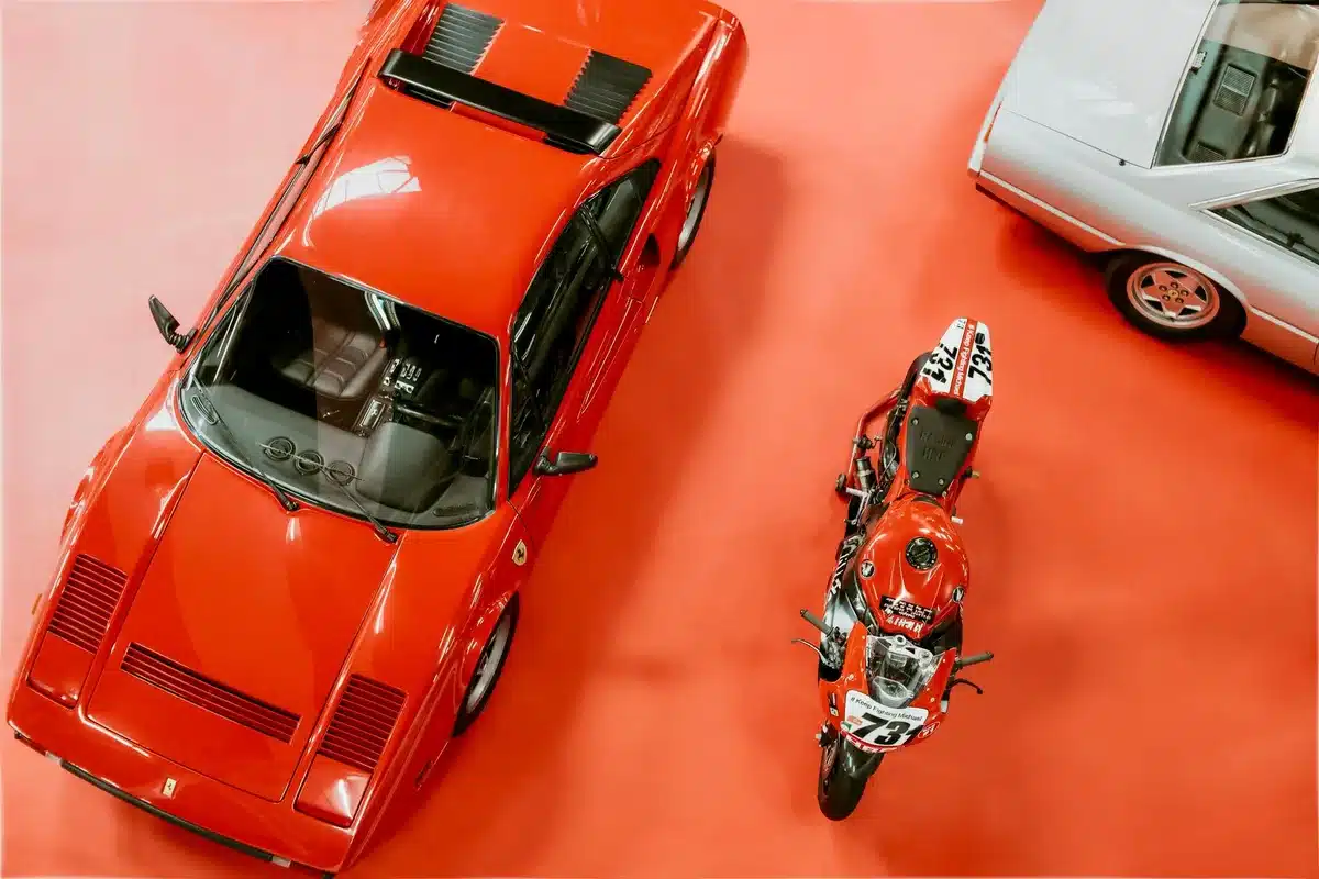 Curated collection of luxury vehicles and motorcycles displayed in a private hangar space