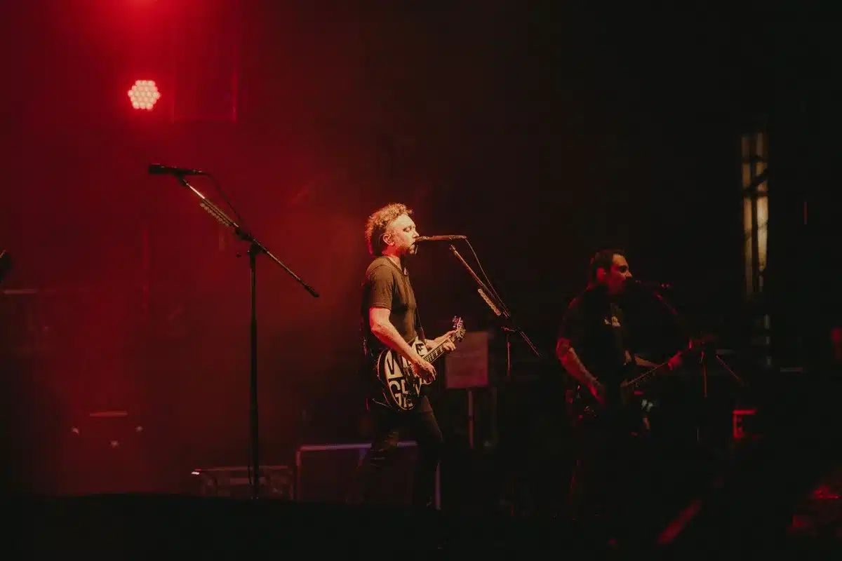 Banda tocando em palco com iluminação de concerto ao vivo