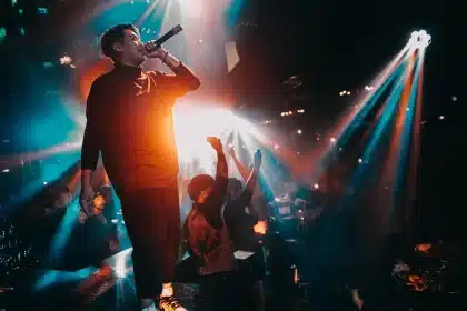 DJ performing at decks under stage lighting during a live set