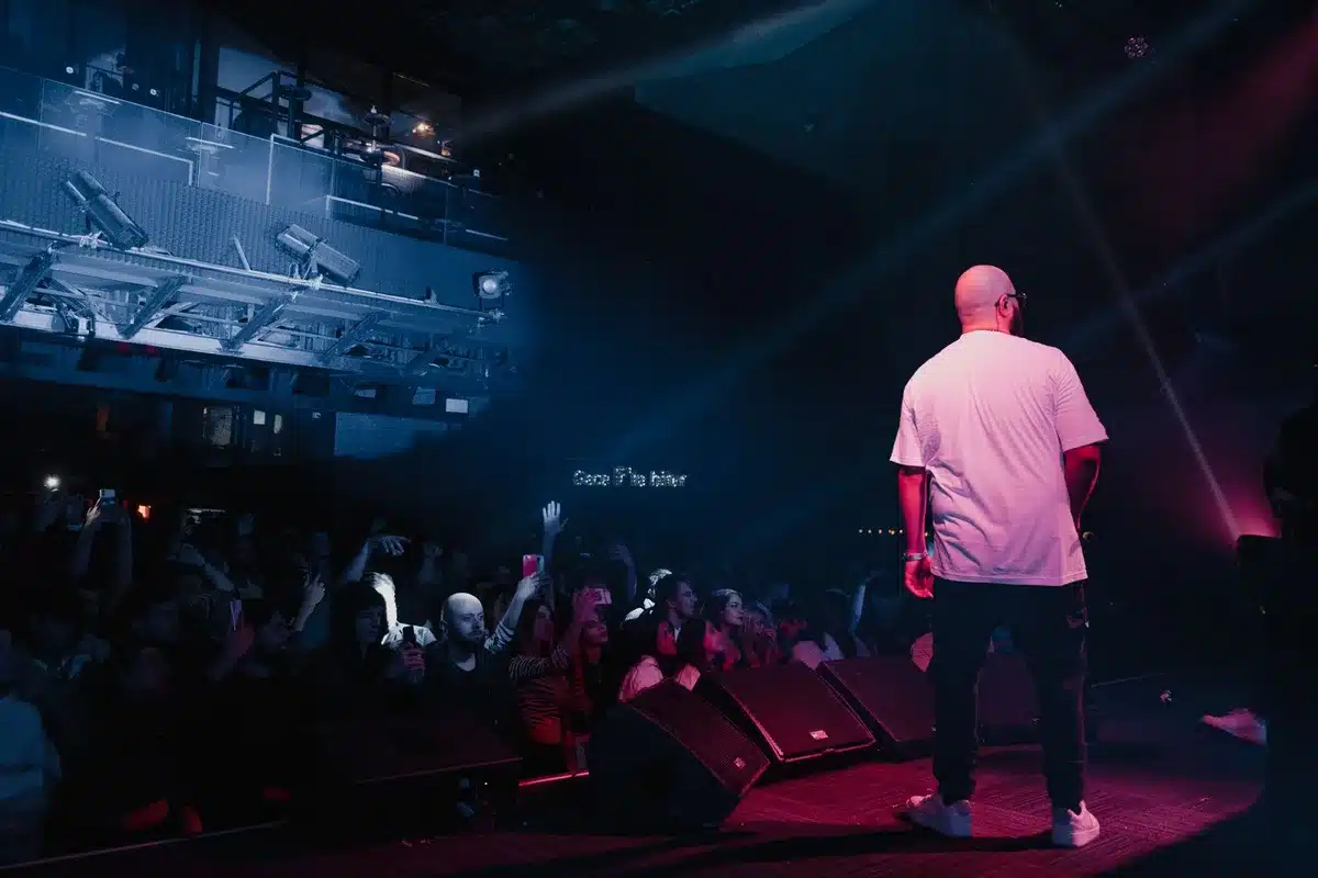 Artist performing an energetic final set under stage lighting