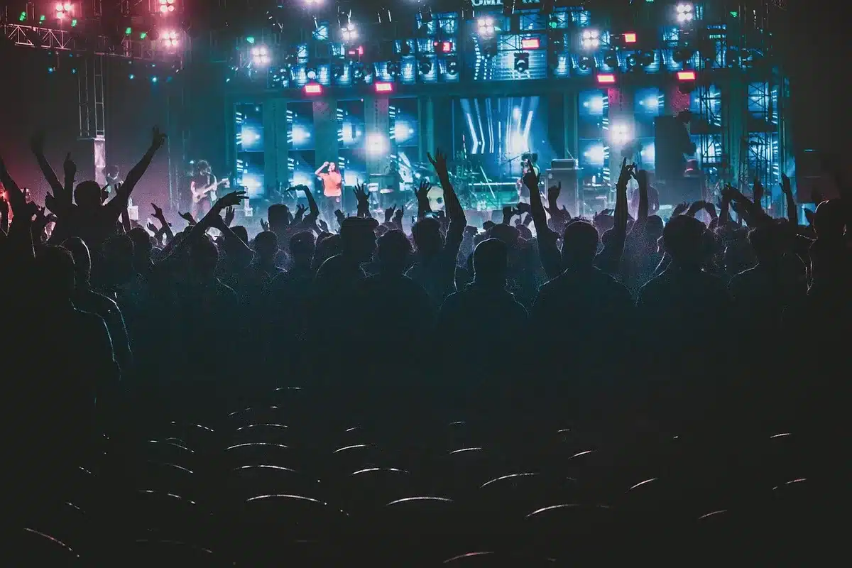 Musicians performing hard rock music on stage with stage lighting and instruments