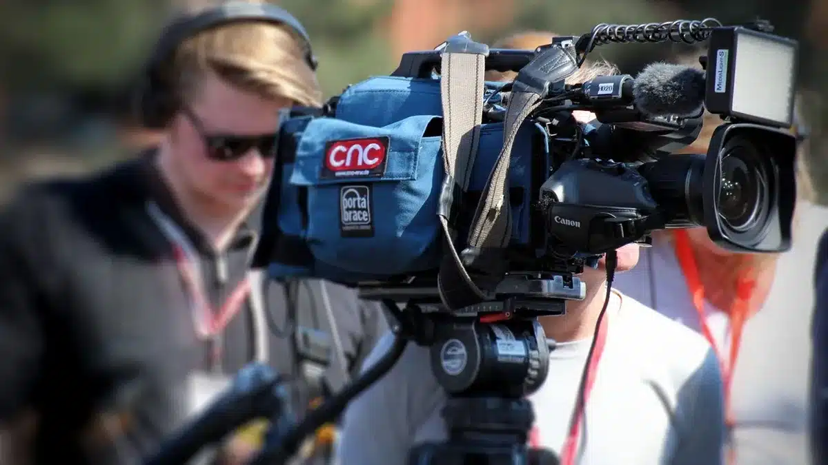 Broadcast studio with multiple cameras filming a live music performance on stage