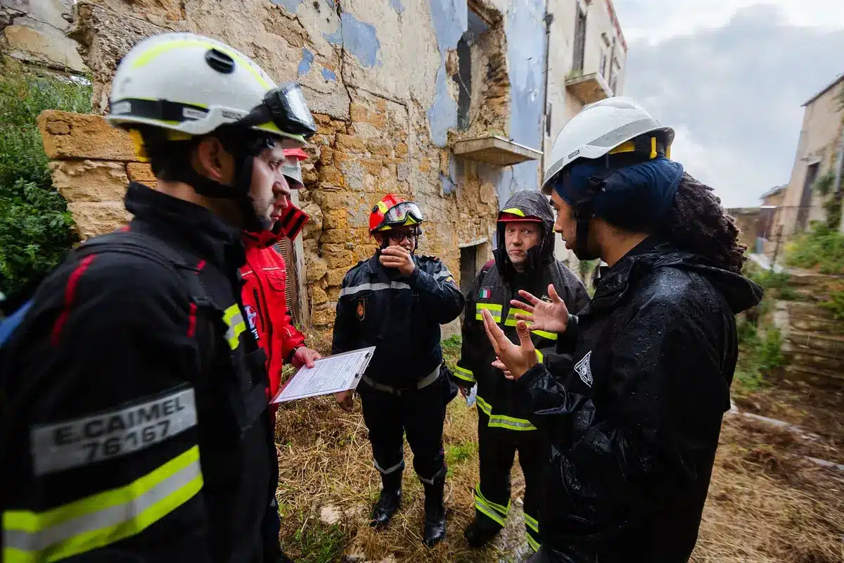 Rescue workers navigating difficult terrain and damaged infrastructure to search for flood survivors