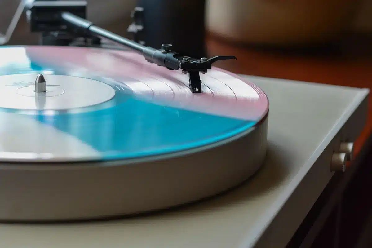 Stack of vinyl records next to a smartphone showing a streaming playlist