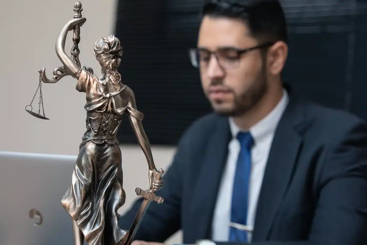 An entertainment lawyer reviewing case files and legal documents in a professional office setting.
