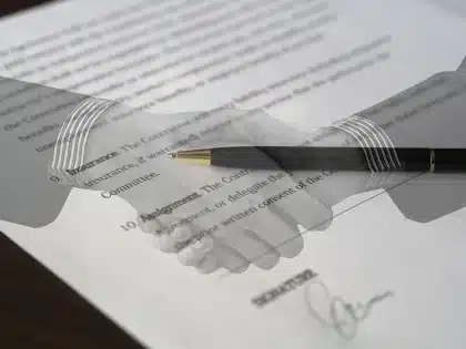 Legal documents and contracts spread across a desk, symbolizing a dispute over film rights and portrayal.