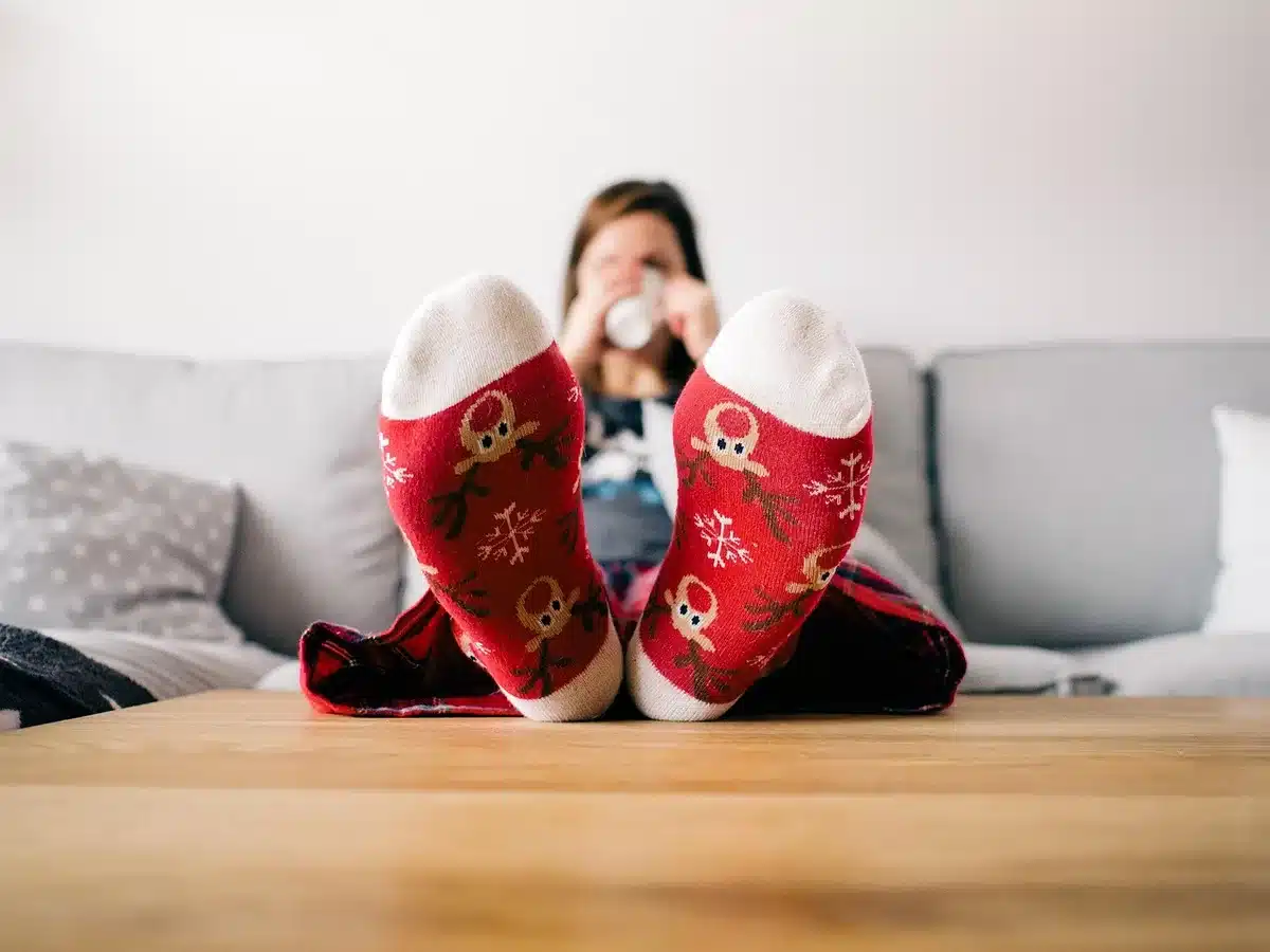 Woman on a couch watching television, visibly emotional