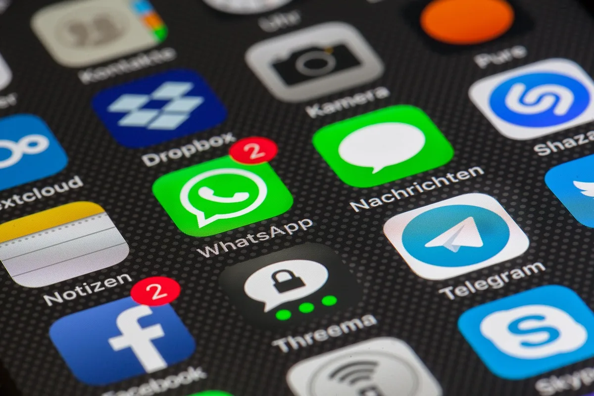 Close-up of a smartphone screen displaying negative comments and threatening messages