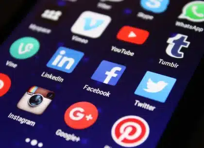 Person viewing disturbing social media messages on a smartphone screen in dim lighting