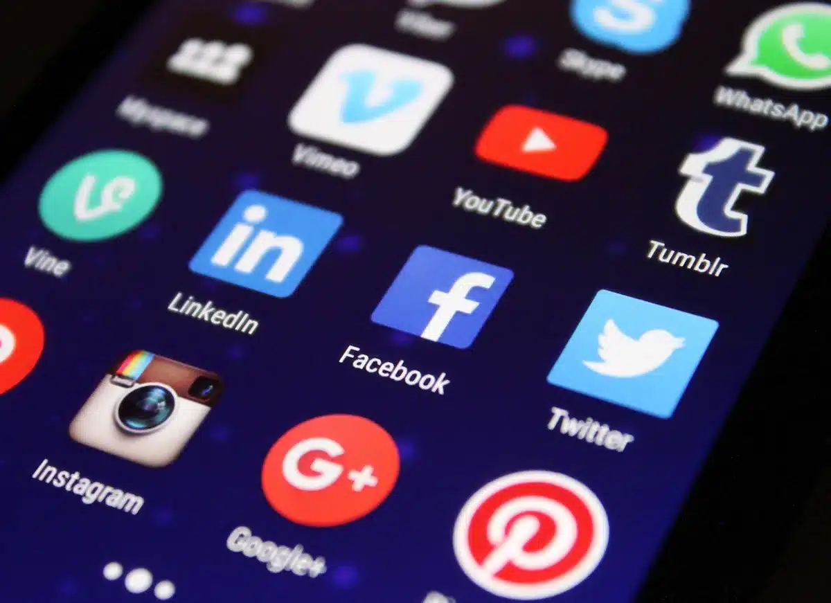Person viewing disturbing social media messages on a smartphone screen in dim lighting