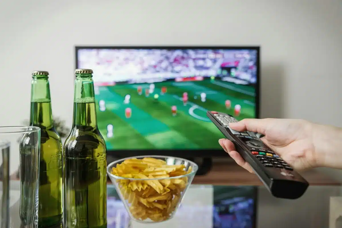 People watching news coverage on a TV in a living room, reacting to political commentary