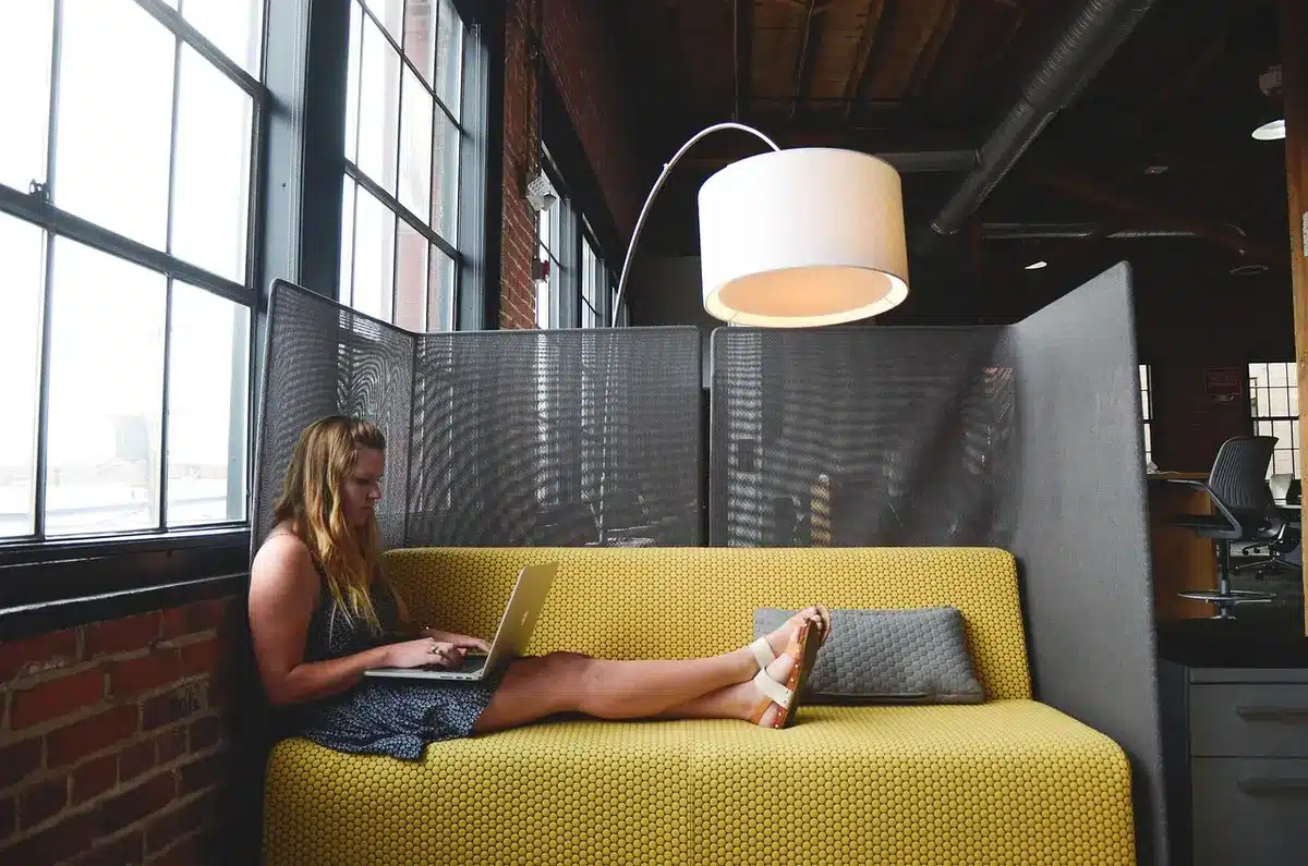Entrepreneur at a small desk with notebook and laptop, symbolizing business and job creation