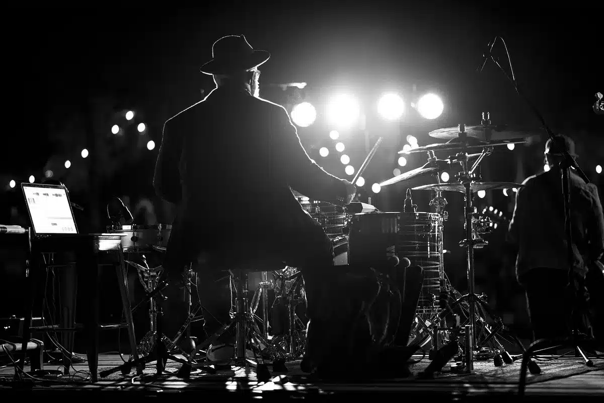 Silhouetted performer on stage with microphone bowing in tribute