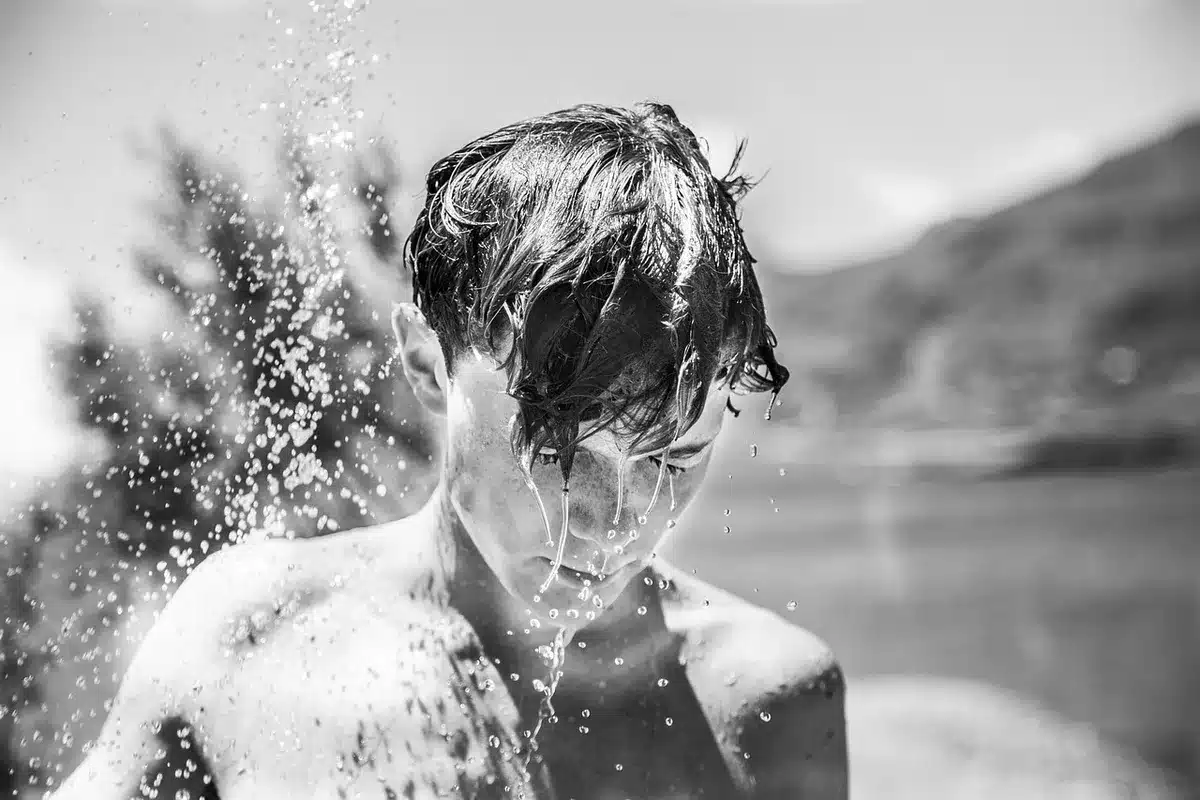Silhouette of a person in a shower reaching toward groin area