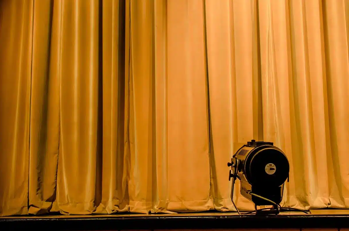 Actors rehearsing onstage under warm stage lights
