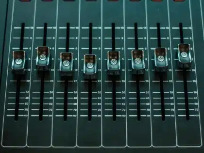 Empty recording studio mixing console and headphones on a desk
