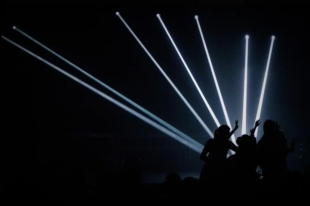 Performer onstage with audience silhouettes at a gala