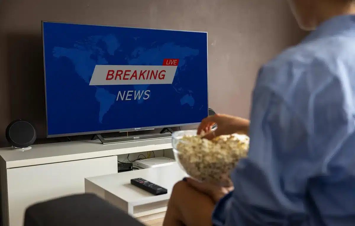 Group of friends on a couch watching movies with popcorn, assembling a watchlist